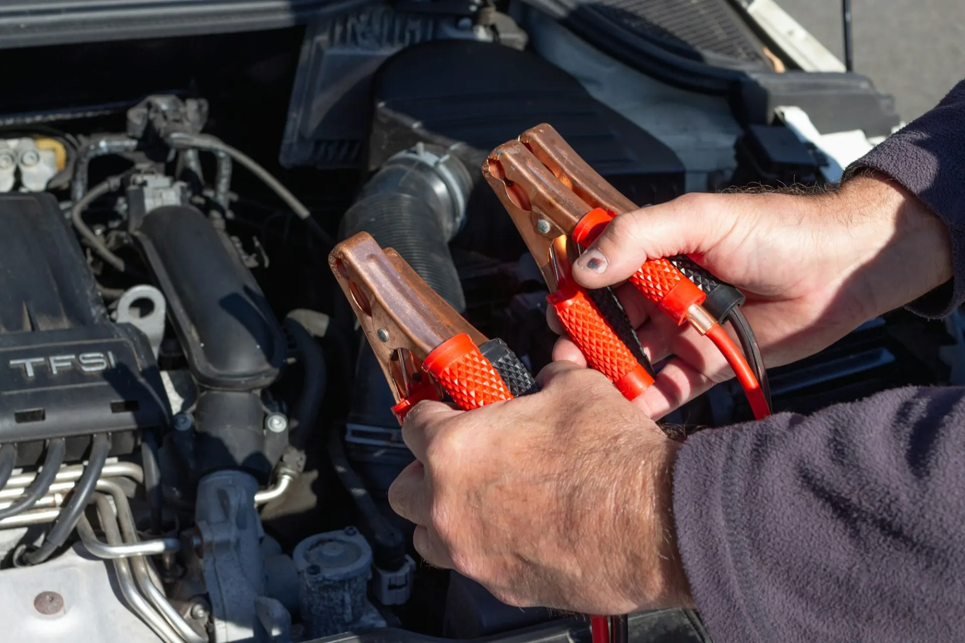Jump leads connected to a car battery