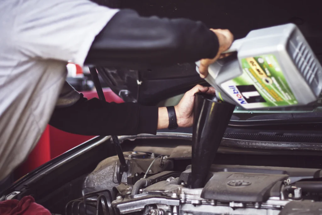 Engine oil being poured into a car engine during an oil change